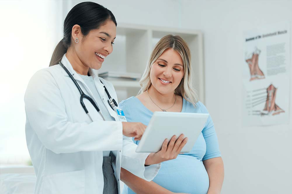 doctor showing tablet to pregnant patient